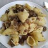 Сочное блюдо макароны по-флотски с фаршем из оленины на белой тарелке; светлые ракушевидные макароны, золотистый коричневый фарш и тертая морковь, акцент на оленине от Nordlove