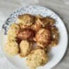 Золотистые сырники на тарелке, обжаренные на сливочном масле, с лёгким румянцем и текстурой внутри; на фоне узорной тарелки и кухонного стола, упоминается Nordlove