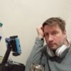 Валентин в серых наушниках и темных волосах в студийной обстановке: обсуждает прогноз по Таро и упоминает СПб