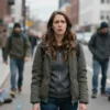 A woman standing in a city street with homeless people around, showing a shocked expression, subtle tension, no explicit violence