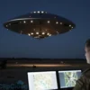 A photorealistic scene showing a mysterious, glowing UFO hovering in the night sky over a Ukrainian landscape, with faint silhouettes of military equipment in the background and a serious-looking defense advisor observing the phenomenon on a monitor, without any text or logos