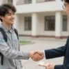 A hopeful university applicant shaking hands with a university official in a modern campus setting, with a subtle visual hint of a half‑million ruble budget being offered, realistic lighting and composition, focusing on the interaction and the academic environment