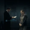 A somber scene showing a grieving mother in modest clothing standing in a dimly lit room, looking distressed while a shady, well-dressed man subtly hands her an envelope, with a faint background hint of a war memorial or military symbols, conveying deception and loss without any visible text or numbers