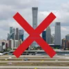 A northern capital city skyline with a large red 'X' over a closed airport, showing the absence of an airport, with a cloudy sky and a subtle map overlay indicating the missing airport location.