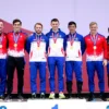 A group of Chuvash sambist athletes standing proudly on a podium after winning three medals at the Russian championship, wearing their competition uniforms and medals around their necks, with a subtle hint of the Russian flag in the background, focusing on the athletes and the medals, no text or letters