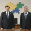 A professional scene showing two judges in formal attire standing beside a dignitary in a modern courtroom in Dagestan, with subtle background elements hinting at the Nizhny Novgorod region such as a stylized map outline or regional colors, all depicted in a realistic, high‑detail style without any visible text or symbols.
