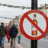 A lively Yaroslavl city street during City Day celebrations, with festive decorations, people in traditional clothing, and a prominent prohibition sign over an alcohol bottle, all in a vibrant, realistic style