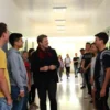 A bright school hallway in Kamyshin with diverse students and a teacher calmly mediating a resolved conflict, smiling faces, open lockers, and natural light, illustrating harmony after a tense situation