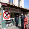 A spring street scene in Mordovia showing a typical local shop that usually sells alcohol now featuring a red prohibition symbol over a bottle, a police officer gently intervening with a customer, pedestrians looking surprised, with regional architecture in the background, no visible text or signage