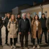 A group of residents of Saransk standing on a dark, poorly lit street (Gozhivsk Street) looking upset and frustrated, with no streetlights illuminating the scene, capturing the mood of discontent and the lack of lighting in a realistic setting