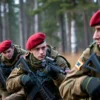 A realistic scene near Smolensk showing special forces soldiers in training, all wearing distinctive maroon berets, performing tactical drills in a forested or open field environment, with military gear and equipment, emphasizing the berets and the testing atmosphere