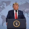 Donald Trump standing at a podium delivering a speech, with a subtle world map backdrop highlighting Iran, conveying a diplomatic atmosphere and the concept of peace proposals, realistic lighting and details, no visible text or symbols