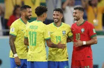 Two national football teams, Brazil and Morocco, celebrating their qualification for the World Cup playoffs. The Brazilian team is wearing yellow jerseys and the Moroccan team is wearing red jerseys. They are embracing and smiling. The background shows a stadium with cheering fans.
