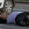 A photorealistic image depicting a pedestrian lying on the ground after being struck by a car. The car is a modern foreign vehicle, partially visible in the background. The scene takes place on a road in Mordovia, Russia. Focus on the aftermath of the accident, showing the impact and the injured person.