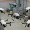 A group of advanced, autonomous drones working together in a complex industrial environment, showcasing their ability to perform tasks independently. The drones should be diverse in design and size, highlighting their technological sophistication. Focus on realistic lighting and detailed textures to convey a sense of scale and functionality.