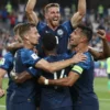 A dynamic image depicting the Scotland national football team celebrating a victory over Haiti during a FIFA World Cup match. The scene should capture the excitement and joy of the moment, with players embracing and raising their arms in triumph. The background should show a blurred stadium with fans in the stands.