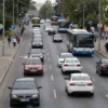 A wide-angle photograph depicting traffic flowing on Leninsky Avenue in Voronezh. Include cars, buses, and pedestrians. The scene should capture the typical daytime activity of the avenue. Focus on realistic lighting and clear visibility of the vehicles and people.