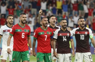 A dynamic image depicting the Moroccan and Scottish national football teams celebrating after a historic match at the World Cup. Focus on the jubilant expressions of the players, with Moroccan players prominently featured. The background should show a blurred stadium filled with cheering fans. Capture the energy and excitement of the moment.