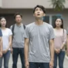 A four-year-old child standing safely on the ground, looking up with a surprised but unharmed expression, surrounded by concerned adults in a residential courtyard, soft daylight, realistic details of clothing and environment