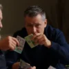 A realistic scene showing a man from Ufa stealing 6 million rubles from elderly pensioners from Sakhalin, with money being handed over or taken, conveying tension and betrayal, no text or numbers visible