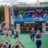 A wide shot of a sports festival opening ceremony in Smolensk, Russia. Many people are gathered, athletes are participating in various sports events, and there are banners and decorations. The scene should be vibrant and energetic, showcasing the spirit of the event.