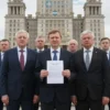 A serious-looking group of Polish parliamentarians standing in front of the city hall of Vinnytsia, Ukraine. They are holding up a document, symbolizing an ultimatum. The scene should convey tension and political pressure.