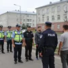 A street scene in Volgograd, Russia, showing a police raid at residential buildings where migrant workers live. Focus on a group of police officers interacting with residents. Include apartment buildings typical of the region. The scene should convey a sense of official activity and community interaction.