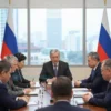 A respectful and official-looking scene depicting a meeting of Russian officials. Several people in formal attire are seated around a large table, engaged in discussion. The setting should be a modern, well-lit conference room with large windows showing a city skyline. Focus on conveying a sense of seriousness and deliberation.