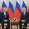 A diplomatic meeting between US and Russian officials. The scene should depict a formal setting, possibly a conference room in a government building. Both officials should be present, engaged in conversation. The atmosphere should be serious and professional.