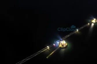 A nighttime aerial view of the Nord Stream pipeline construction site, with subtle glows emanating from underwater construction lights. Focus on the scale of the project and the dark, expansive sea. No visible ships or other vessels.
