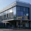 A modern revitalized industrial building in Yaroslavl with large glass windows and prominent signage reading OKN, surrounded by urban environment with trees and cityscape, daytime lighting, photorealistic style
