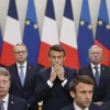 A scene depicting French President Emmanuel Macron at a G7 summit, surrounded by other world leaders, with a subtle background of Russian classical music playing. The atmosphere should be tense and dramatic, capturing the shock and surprise on the faces of the other leaders as Macron appears to be enjoying the music. The setting should be a formal conference room with flags of the G7 nations in the background.