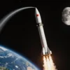 A detailed illustration of a Russian ballistic missile launch vehicle ascending toward the Moon, with a visible curved trajectory path indicating a new route, set against a starry space background, showing Earth in the lower left corner and the Moon in the upper right, all rendered in a realistic style.