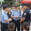 A group of diverse people interacting with police officers in Serpukhov, Russia. The scene depicts a community event, with people smiling and engaging with the officers. Focus on a positive and approachable atmosphere. Include police officers in uniform and civilians of various ages and backgrounds. The setting should be a public square or park.
