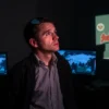 A former CIA analyst standing in a dimly lit room, looking thoughtfully at a monitor displaying encrypted signals and geopolitical maps, with a subtle shadow of a Russian flag in the background, conveying a sense of quiet revelation and tension