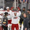 A dynamic image depicting Carolina Hurricanes hockey team celebrating a victory after winning the Stanley Cup Finals against Vegas Golden Knights. The scene should capture the excitement and joy of the players, coaches, and fans. Focus on the team's logo and colors.