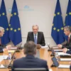 A formal meeting of EU leaders around a large table. Several leaders are visible, engaged in discussion. The room is decorated with EU flags. Focus on the serious and unified atmosphere.