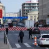 A wide shot of Saransk city center, showing traffic restrictions in place. Include road closures, police presence, and pedestrian traffic. Focus on the urban environment and the impact of the restrictions on daily life.