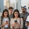 A diverse group of children (ages 6-14) in the UAE, looking concerned while holding their smartphones. The background shows a modern cityscape with iconic UAE architecture. Focus on their expressions and the sense of change.