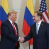 Donald Trump congratulating Gustavo Petro, the newly elected president of Colombia, during a formal meeting. The scene should be respectful and diplomatic, reflecting the significance of the event. Include Colombian and American flags subtly in the background.