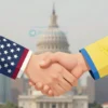 A stylized depiction of a handshake between two figures, one representing the United States (perhaps subtly symbolized by an eagle or stars) and the other representing Ukraine (perhaps subtly symbolized by a wheat stalk or a blue and yellow color scheme). The background should be a neutral, slightly blurred cityscape suggesting a diplomatic setting. Focus on conveying a sense of negotiation and potential agreement.