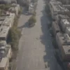 A wide shot of a modern city street in Yaroslavl Oblast, Russia. The scene depicts a bustling urban environment with people walking, cars driving, and buildings of various architectural styles. The overall atmosphere should be bright and optimistic, reflecting the lifting of the drone danger regime. Focus on capturing the everyday life of the city.
