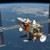 A sleek, futuristic satellite, the SX-V, orbiting Earth. The satellite has a complex array of solar panels and communication dishes. Earth is visible in the background, showing continents and oceans. The overall scene should convey technological advancement and space exploration.