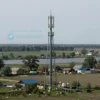 A wide shot of a rural landscape in the Volgograd region of Russia. Include fields, a river, and a few scattered houses. The sky should be overcast. Focus on the natural beauty of the region and the impact of the mobile network outage.