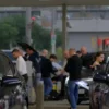 A photo-realistic image of a diverse group of Ulyanovsk drivers refueling their cars at a modern gas station. The scene should depict various car models (sedans, SUVs, etc.) and people of different ages and ethnicities. Focus on the atmosphere of a typical gas station with pumps, signage, and people interacting.