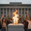 A symbolic representation of the Central Election Commission building subtly blended with a large, glowing catalyst element, such as a bright, abstract flame or spark, emanating from a ballot box, surrounded by a crowd of diverse, faceless protesters raising their fists, all set against a muted urban backdrop that suggests tension and unrest without any visible text or signage