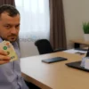 A modern office setting in Stavropol with a cybercrime investigator holding a stack of cash representing 1.2 million rubles, a laptop displaying cryptocurrency symbols, and a confiscated hard drive, all under a serious investigative atmosphere