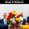 A bouquet of flowers crafted to resemble a Slavic unity symbol, presented to the head of Belarus. The flowers should be arranged in a formal, respectful manner. The background should be neutral and slightly blurred to focus on the bouquet and the person receiving it.