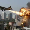 A military aircraft releasing bombs over a cityscape with explosions and smoke rising from buildings, showing the aftermath of an airstrike in an urban area