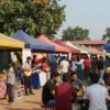 A vibrant festival scene in Telvi with colorful tents, people enjoying music and food, and a lively atmosphere under a sunny sky